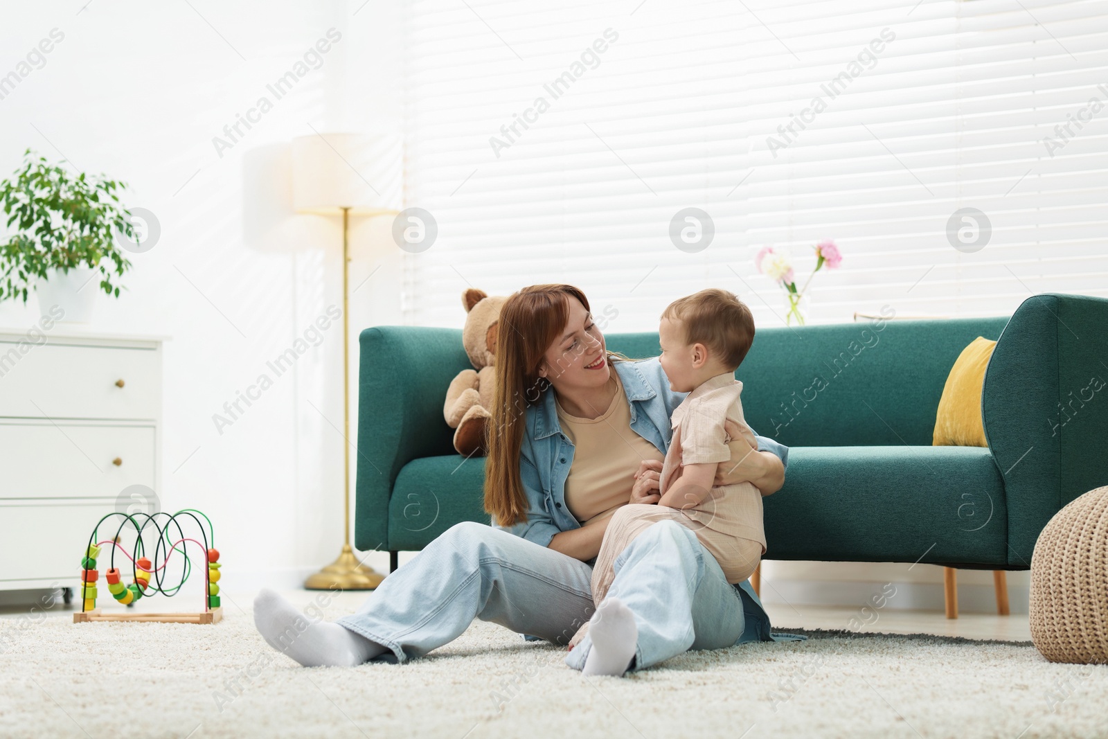 Happy mother spending time together with her son on floor at home Photo of Happy mother spending time together with her son on floor at home