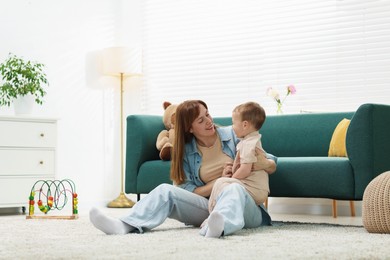 Photo of Happy mother spending time together with her son on floor at home
