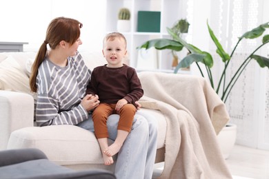 Photo of Mother spending time together with her son on sofa at home