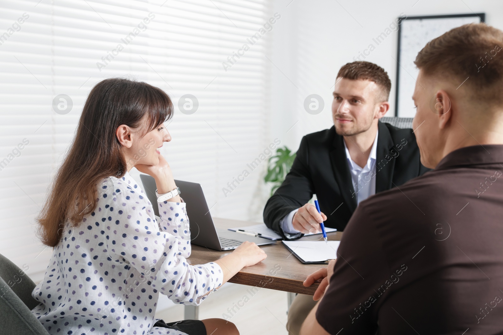 Couple having meeting with business consultant at table in office Photo of Couple having meeting with business consultant at table in office