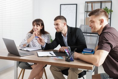 Photo of Couple having meeting with business consultant at table in office