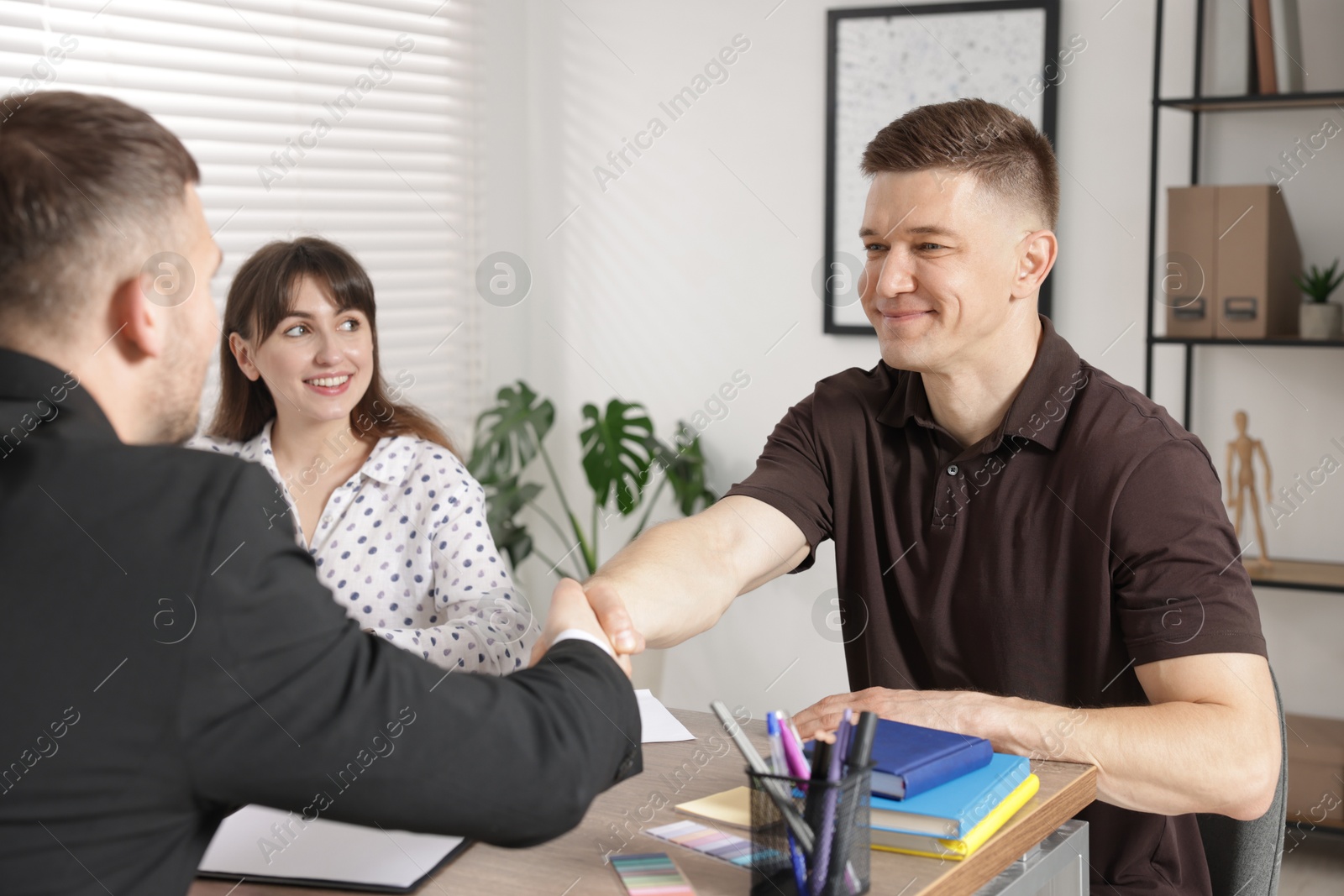 Couple having meeting with business consultant at table in office Photo of Couple having meeting with business consultant at table in office