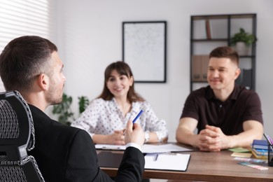 Photo of Couple having meeting with business consultant at table in office, selective focus