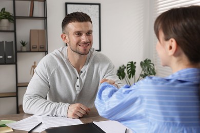 Photo of Consultant working with client at table in office. Business meeting