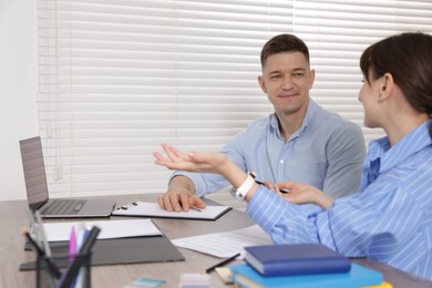 Photo of Consultant working with client at table in office. Business meeting