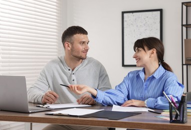 Photo of Consultant working with client at table in office. Business meeting