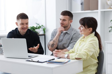 Photo of Couple having meeting with business consultant at table in office