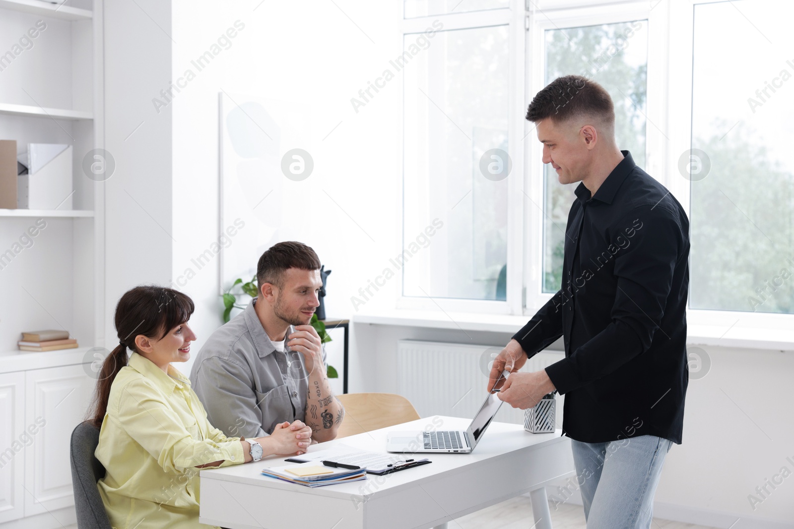 Couple having meeting with business consultant at table in office Photo of Couple having meeting with business consultant at table in office