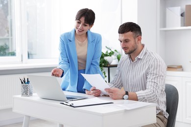 Photo of Consultant working with client at table in office. Business meeting