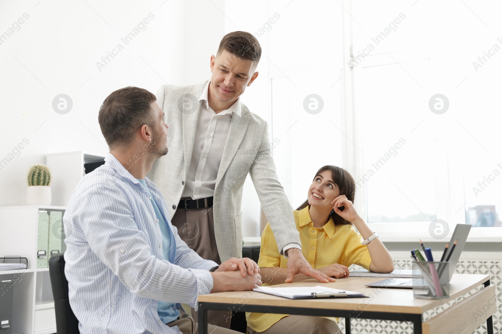 Couple having meeting with business consultant at table in office Photo of Couple having meeting with business consultant at table in office