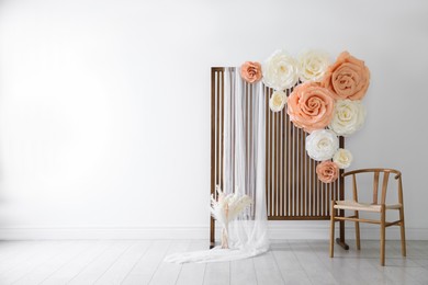 Photo of Photo zone with beautiful floral decor in studio