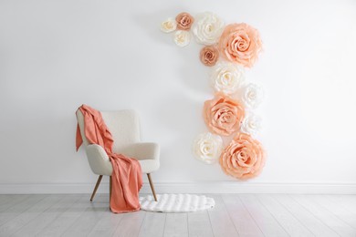 Photo of Photo zone with beautiful floral decor and armchair in studio