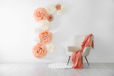 Photo of Photo zone with beautiful floral decor and armchair in studio