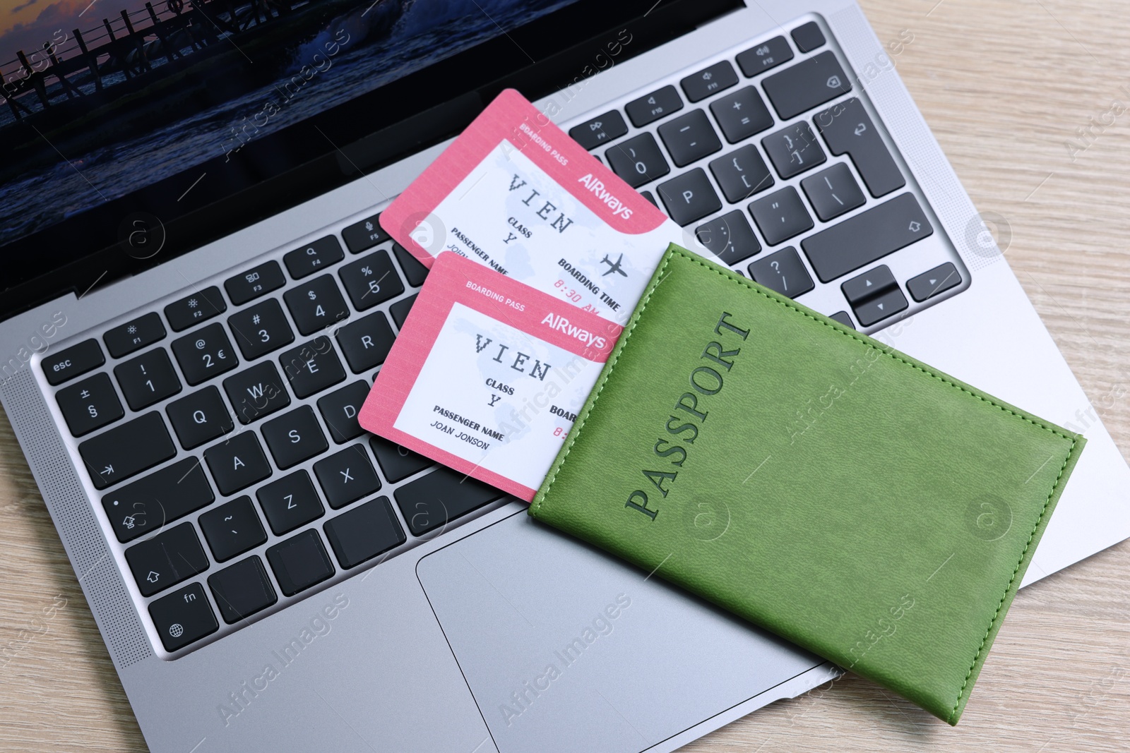 Passport, tickets and laptop on light wooden table, top view Photo of Passport, tickets and laptop on light wooden table, top view