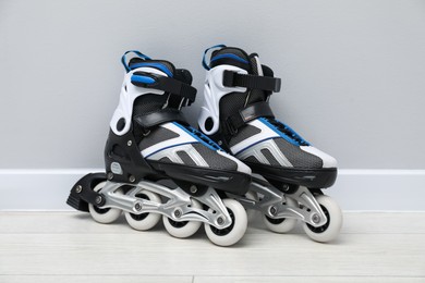 Photo of Pair of roller skates on floor near white wall