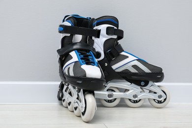 Photo of Pair of roller skates on floor near white wall