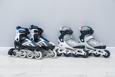 Photo of Pairs of roller skates on floor near white wall