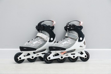 Photo of Pair of roller skates on floor near white wall