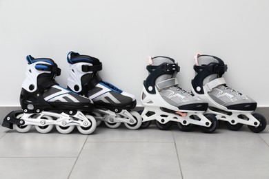 Photo of Pairs of roller skates on floor near white wall