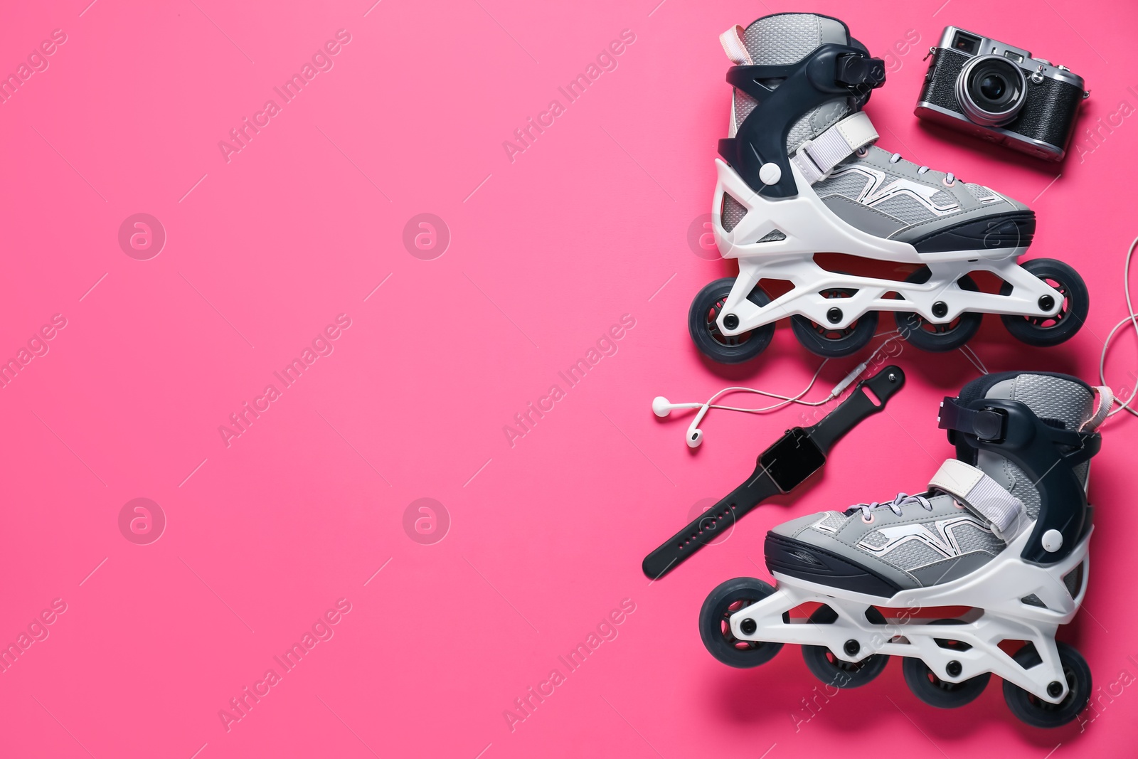Flat lay composition with roller skates on pink background. Space for text Photo of Flat lay composition with roller skates on pink background. Space for text