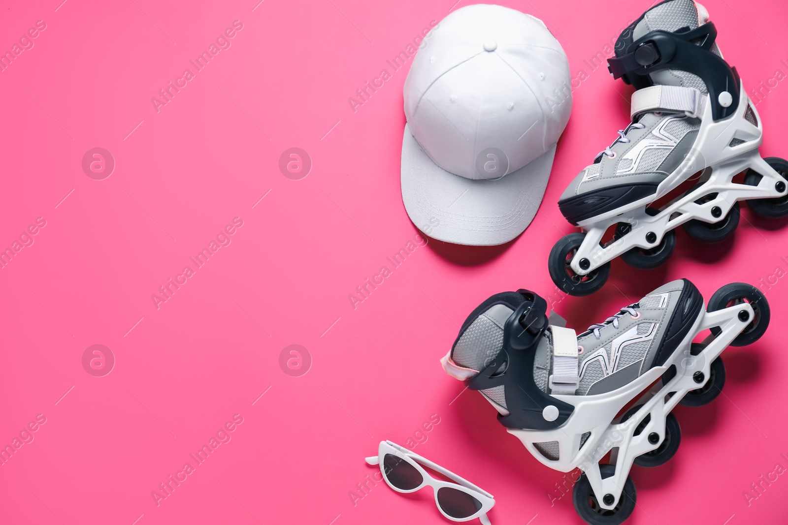 Flat lay composition with roller skates on pink background. Space for text Photo of Flat lay composition with roller skates on pink background. Space for text