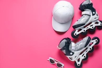 Photo of Flat lay composition with roller skates on pink background. Space for text