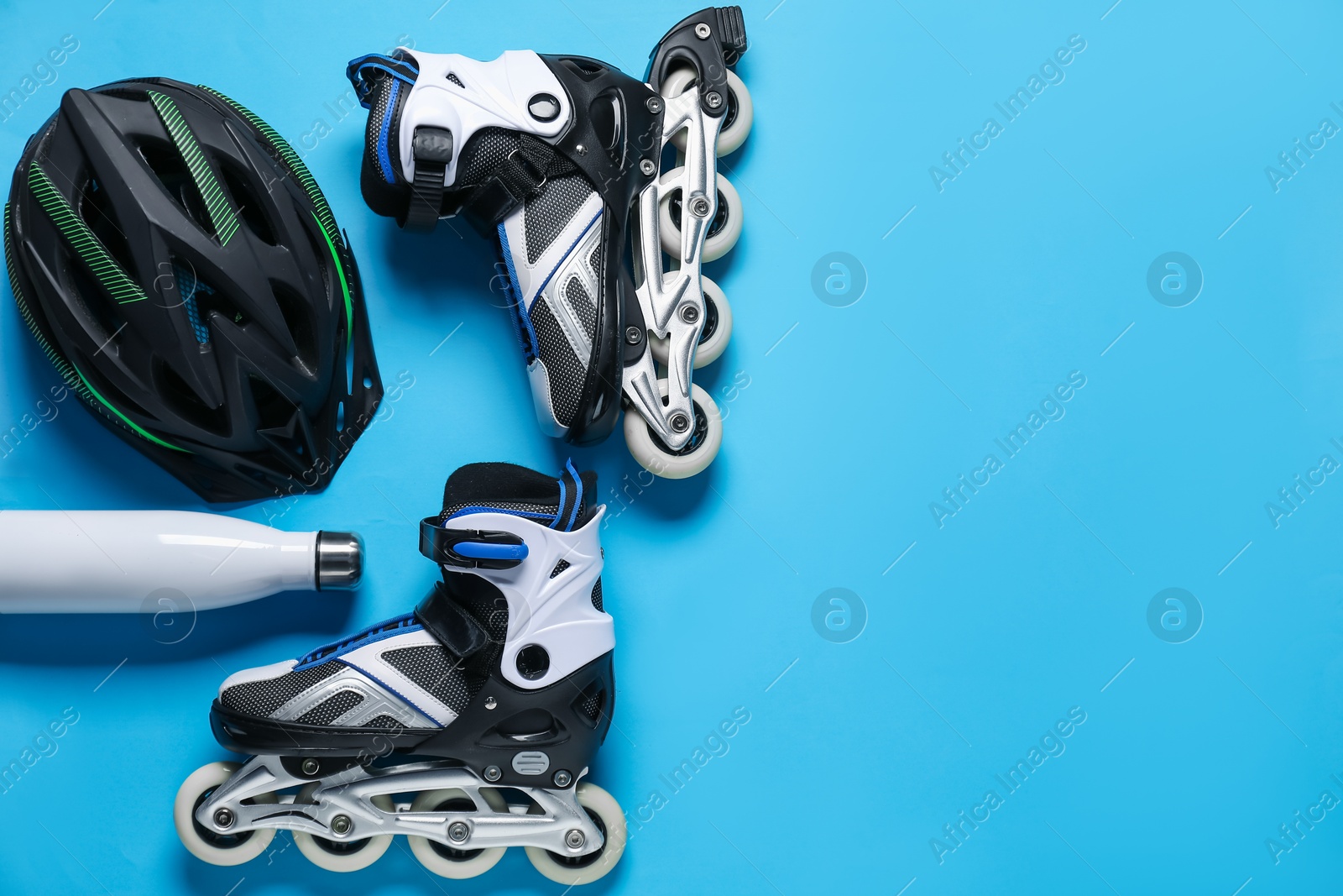 Flat lay composition with roller skates on blue background. Space for text Photo of Flat lay composition with roller skates on blue background. Space for text