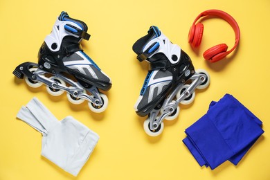 Photo of Flat lay composition with roller skates on yellow background