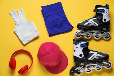 Photo of Flat lay composition with roller skates on yellow background