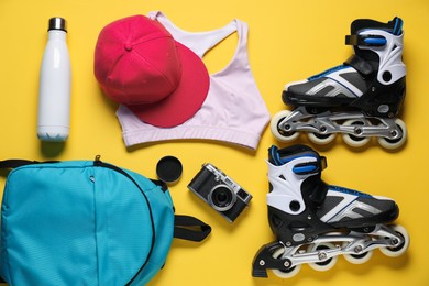 Photo of Flat lay composition with roller skates on yellow background