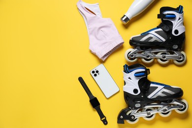 Photo of Flat lay composition with roller skates on yellow background. Space for text
