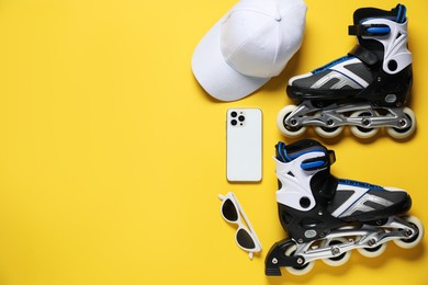 Photo of Flat lay composition with roller skates on yellow background. Space for text