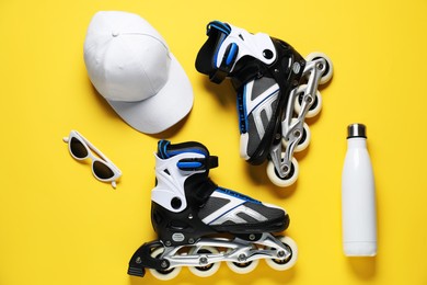 Photo of Flat lay composition with roller skates on yellow background