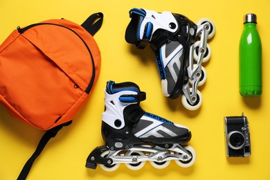 Photo of Flat lay composition with roller skates on yellow background