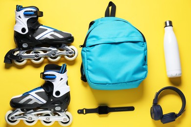 Photo of Flat lay composition with roller skates on yellow background