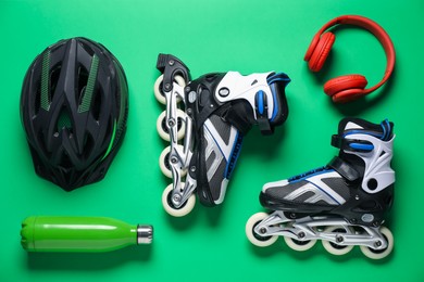 Photo of Flat lay composition with roller skates on green background