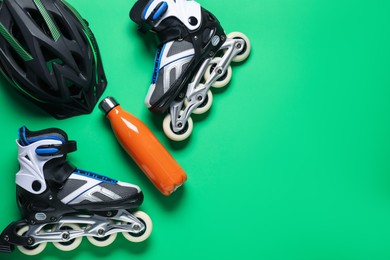 Photo of Flat lay composition with roller skates on green background. Space for text