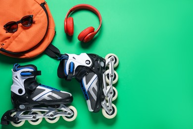 Photo of Flat lay composition with roller skates on green background. Space for text