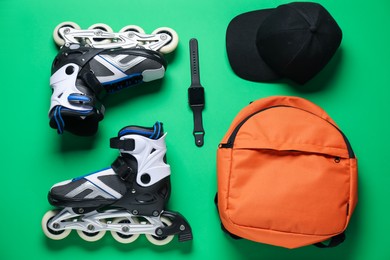 Photo of Flat lay composition with roller skates on green background