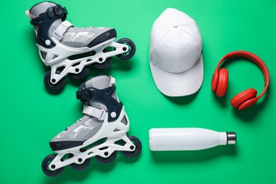 Photo of Flat lay composition with roller skates on green background