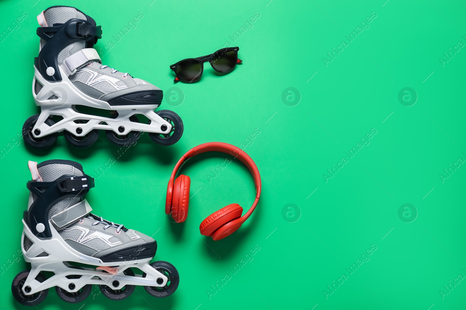 Flat lay composition with roller skates on green background. Space for text Photo of Flat lay composition with roller skates on green background. Space for text