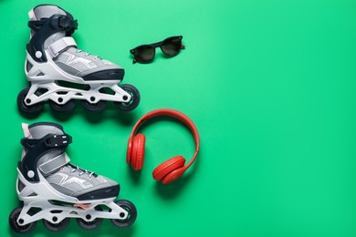 Photo of Flat lay composition with roller skates on green background. Space for text