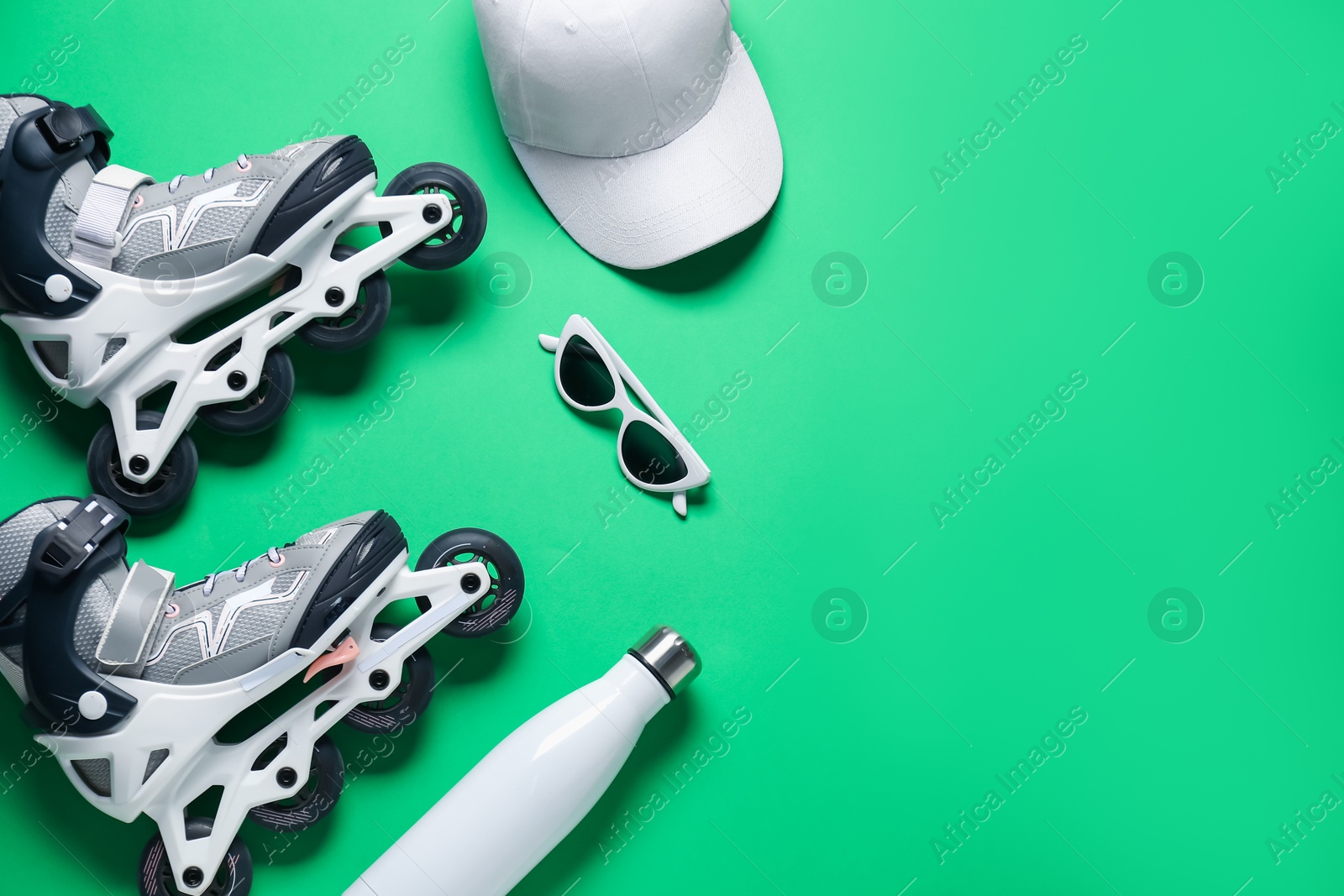 Flat lay composition with roller skates on green background. Space for text Photo of Flat lay composition with roller skates on green background. Space for text