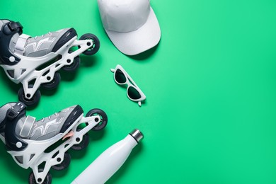 Photo of Flat lay composition with roller skates on green background. Space for text