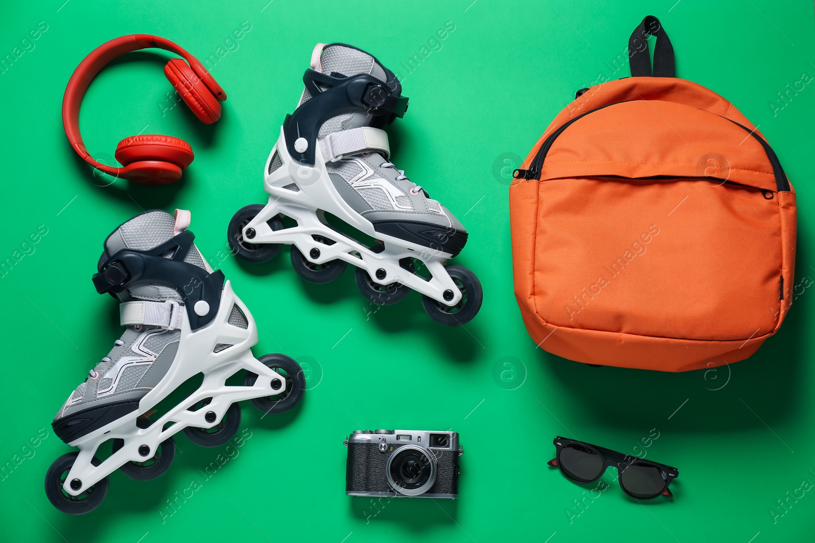 Flat lay composition with roller skates on green background Photo of Flat lay composition with roller skates on green background