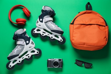 Photo of Flat lay composition with roller skates on green background