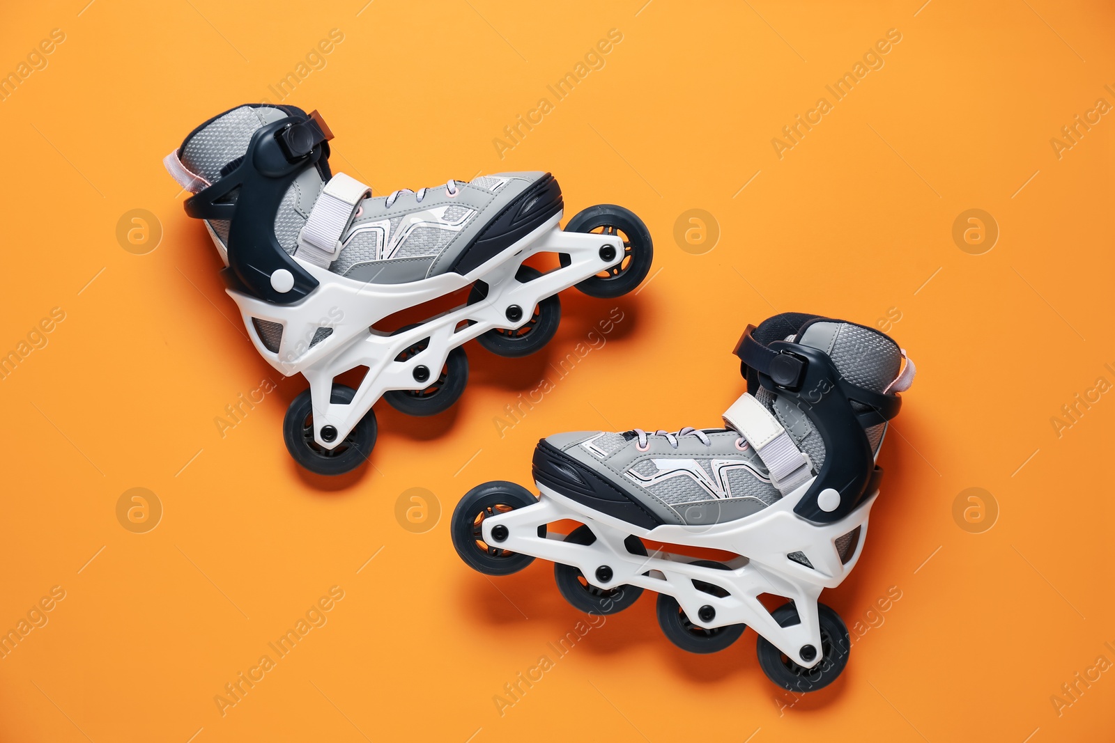 Pair of roller skates on orange background, top view Photo of Pair of roller skates on orange background, top view