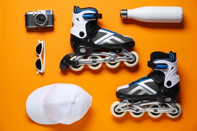 Photo of Flat lay composition with roller skates on orange background