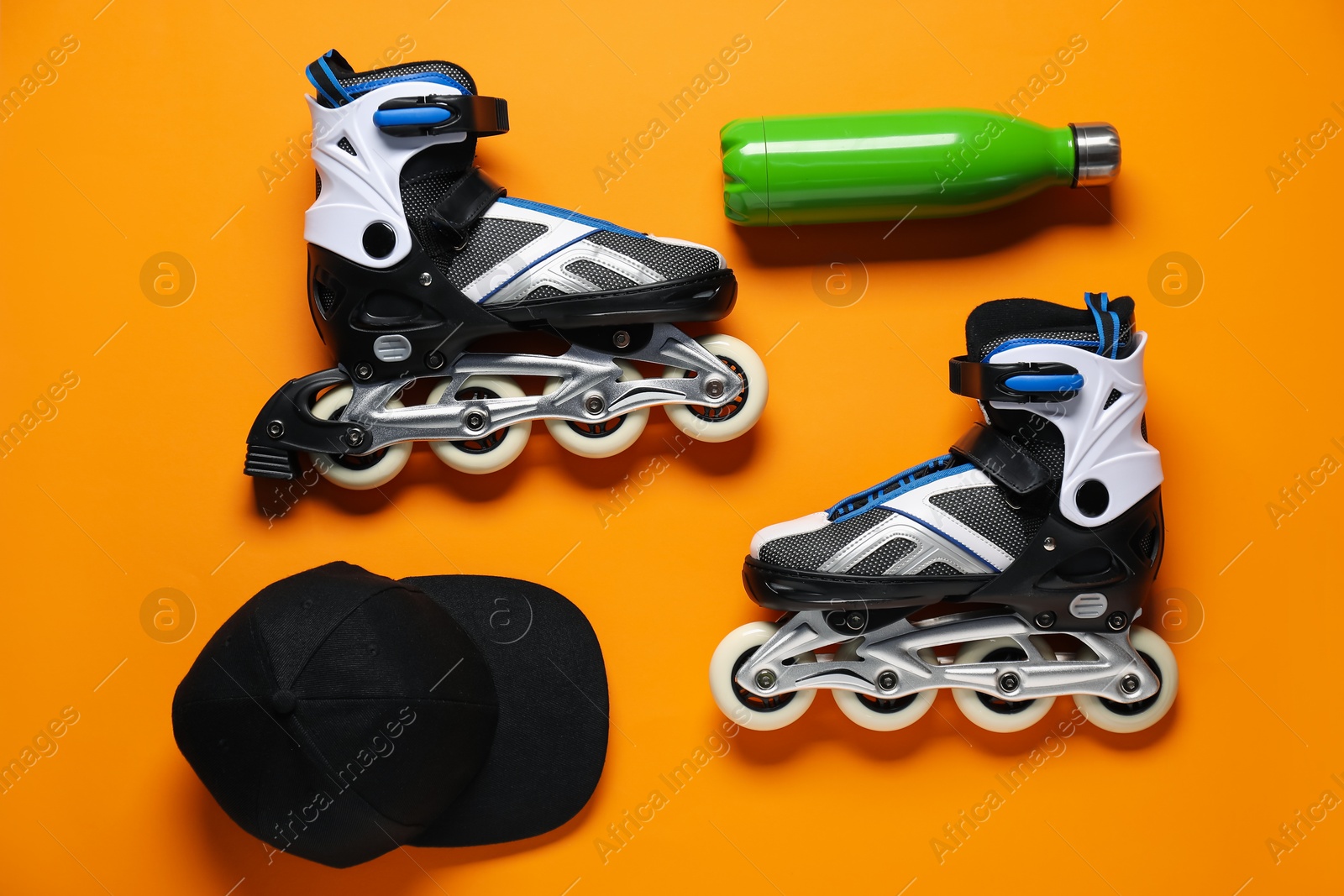 Flat lay composition with roller skates on orange background Photo of Flat lay composition with roller skates on orange background