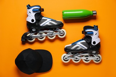 Photo of Flat lay composition with roller skates on orange background